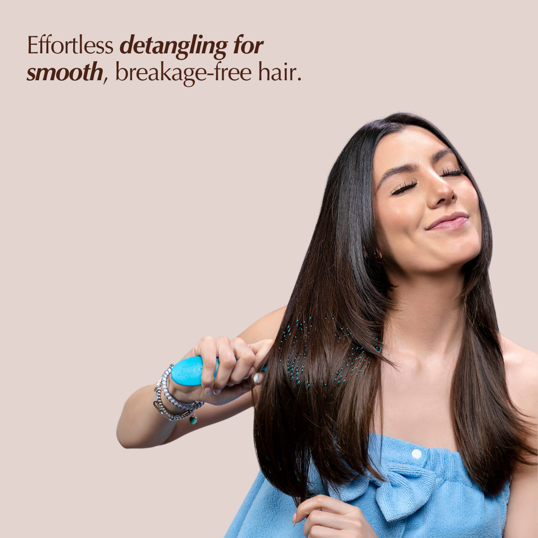 A woman using REV-320 detangler brush to her hair