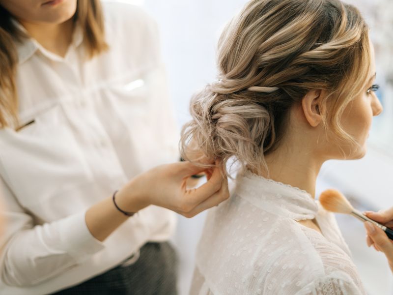 A woman doing protective hairstyles on her head
