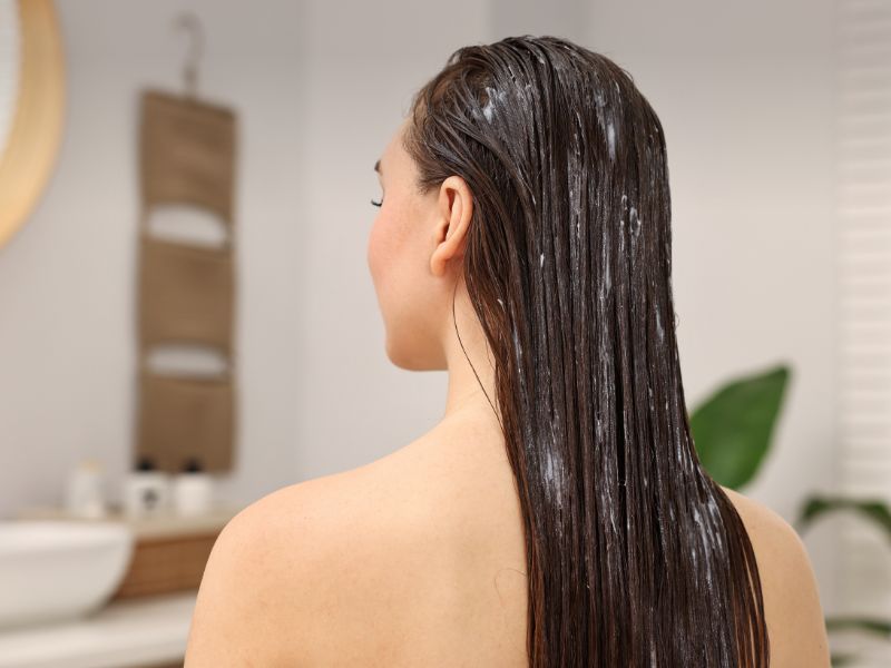 Woman with Hair Conditioner in Bathroom