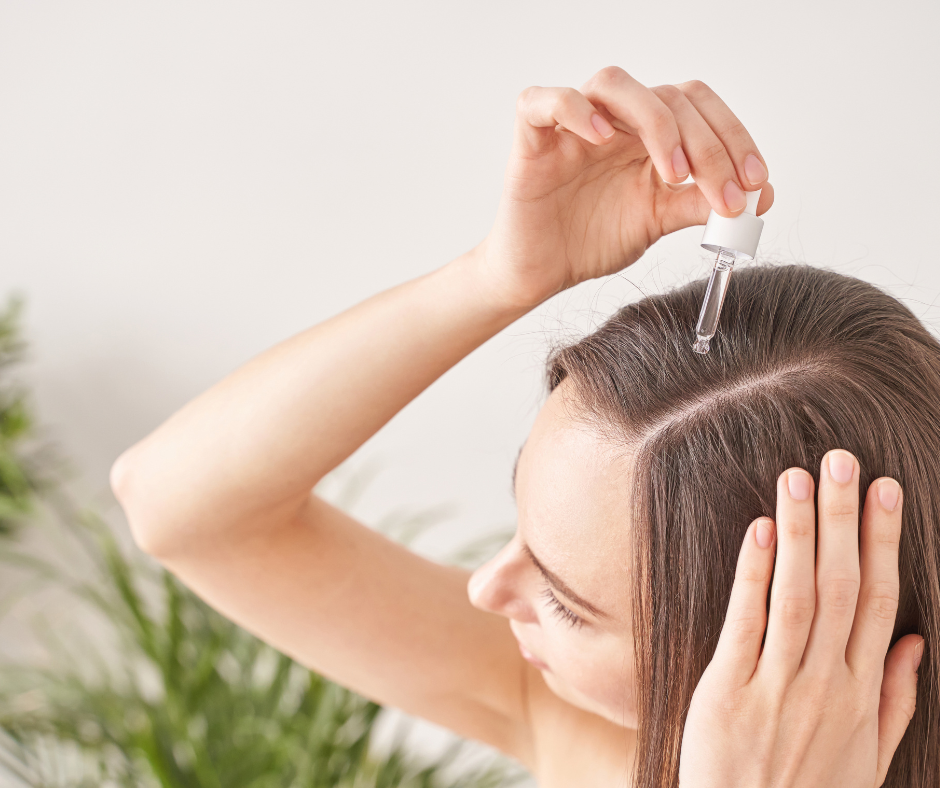 Woman applying vitamins serum to her hair