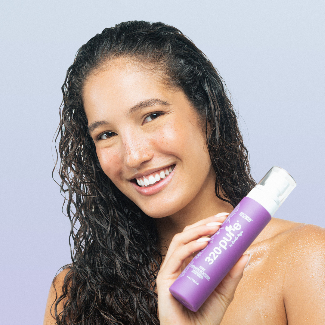 Woman holding 320 Pure Hair Vitamin Booster from REV320