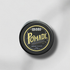 Black container of iboss pomade with gold text on a gray background